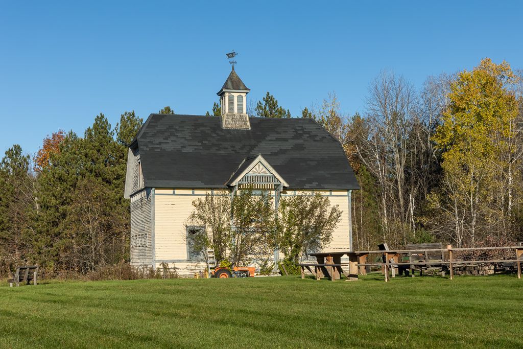 A barn with a weather vane on top of it