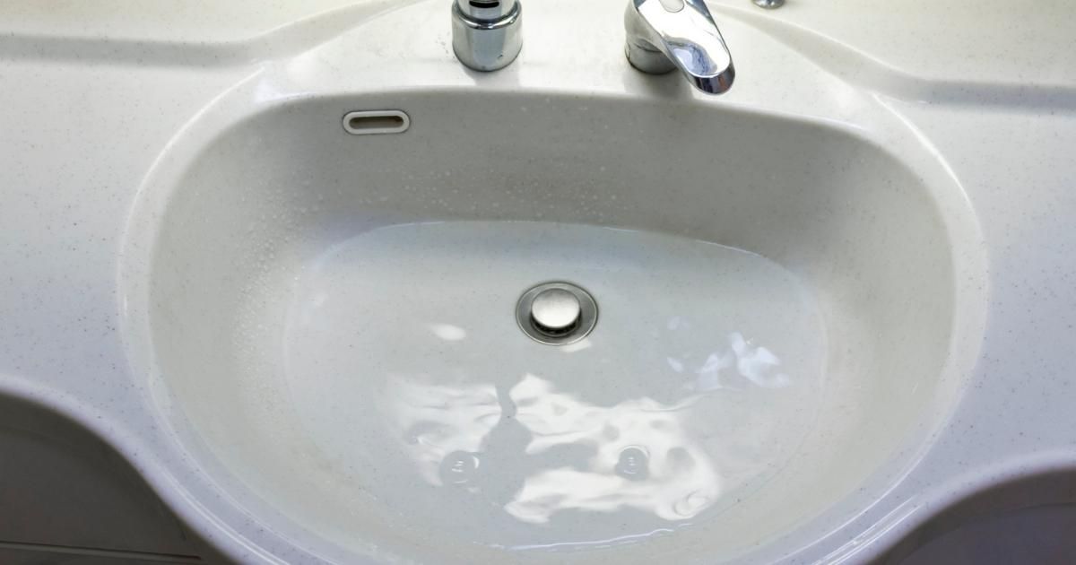 Bathroom sink with standing water indicating a clogged drain