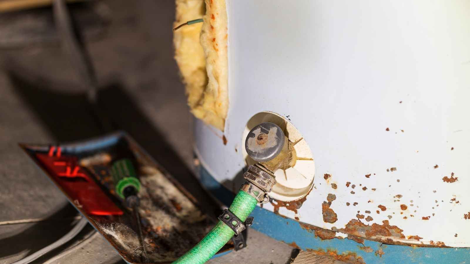 Evidence that a replacement water heater is needed with a picture of a damaged tank.
