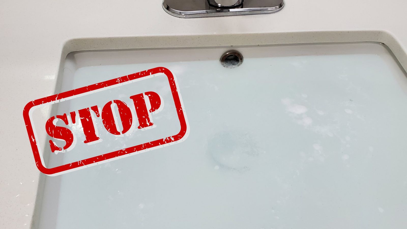 A clogged sink with a 'Stop' graphic overlaid.