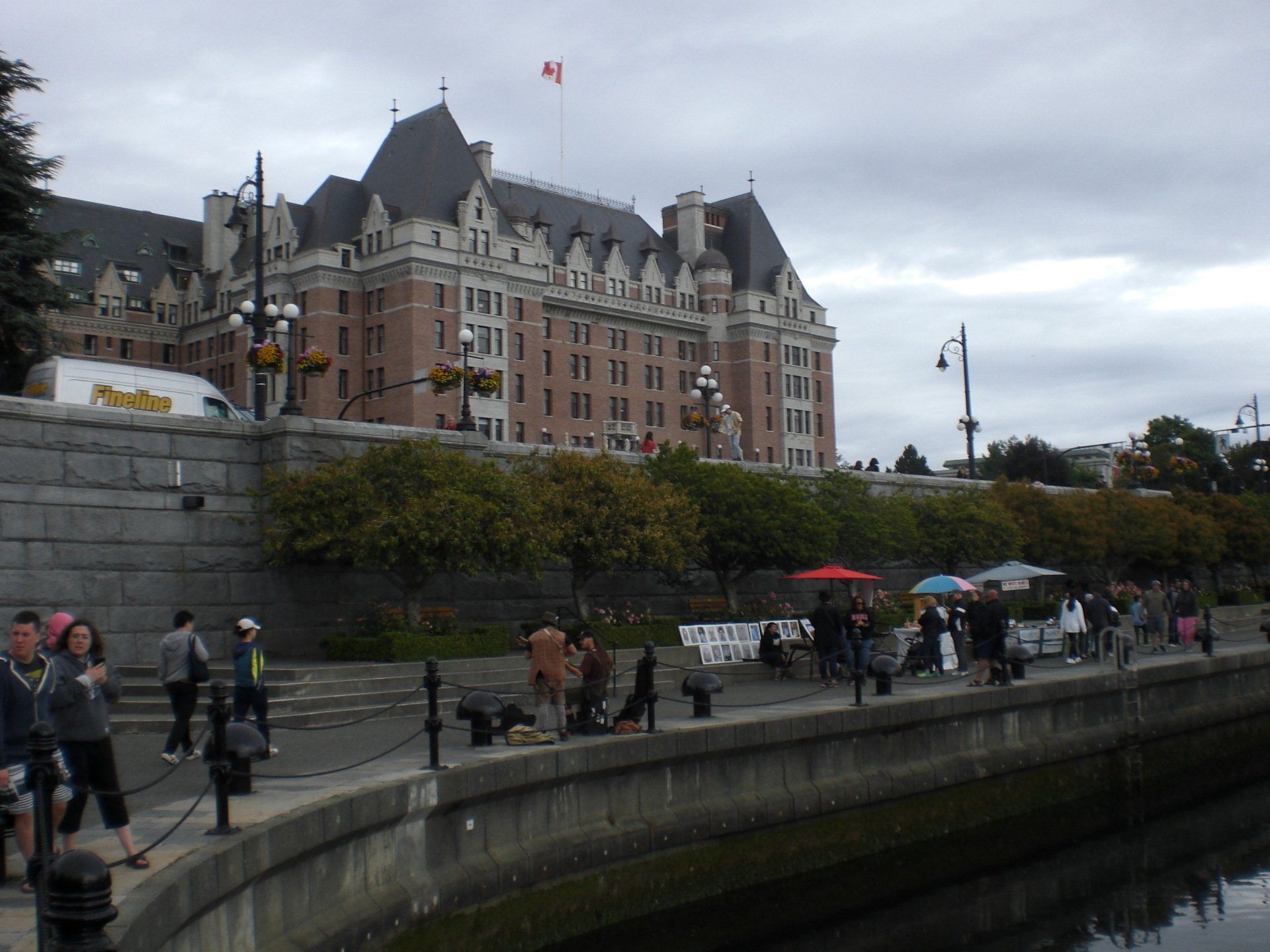 Fairmont Empress Hotel in Victoria, BC, on overcast day; people walking along the waterfront.