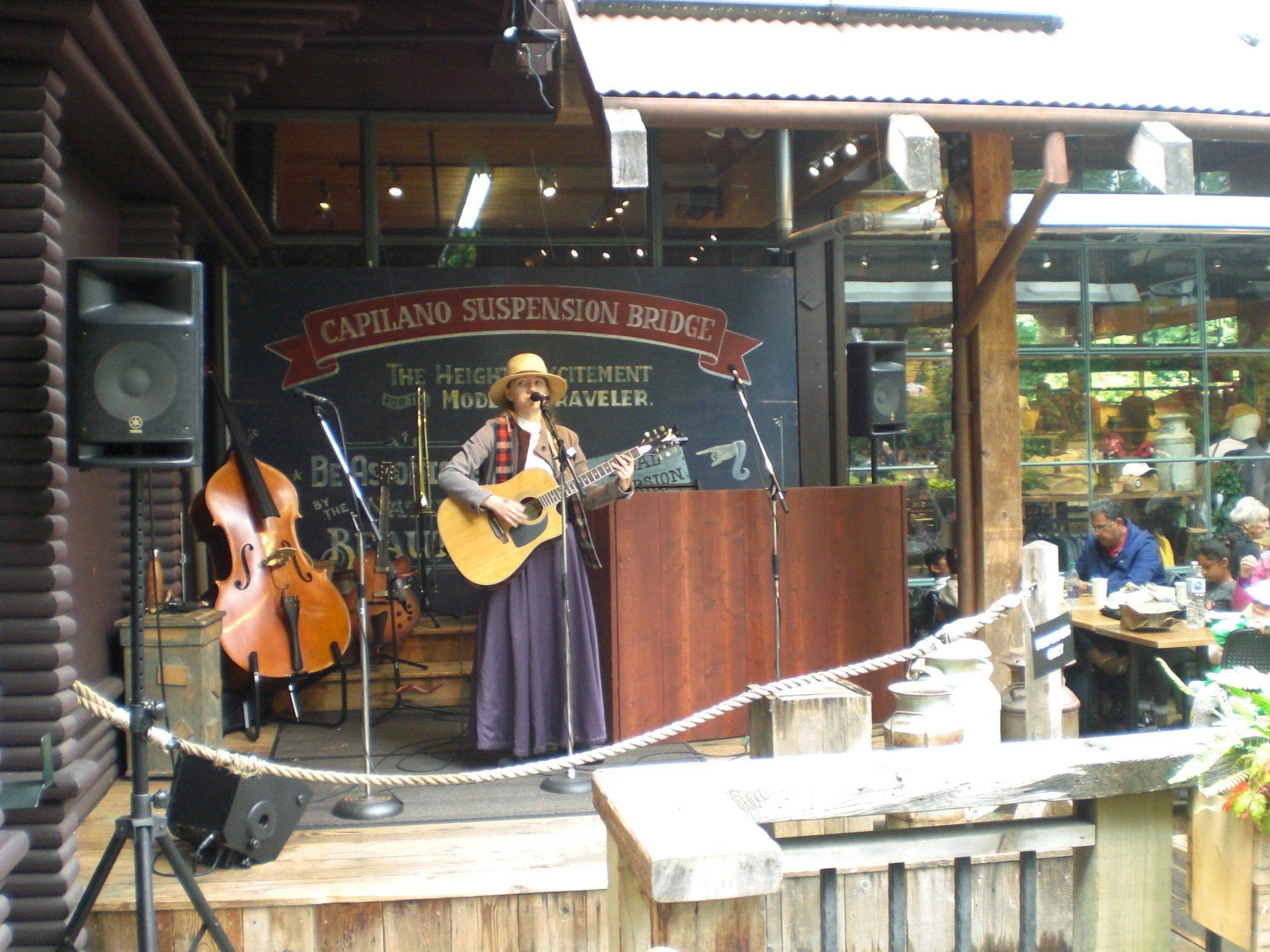 Woman playing guitar onstage at Capilano Suspension Bridge restaurant.