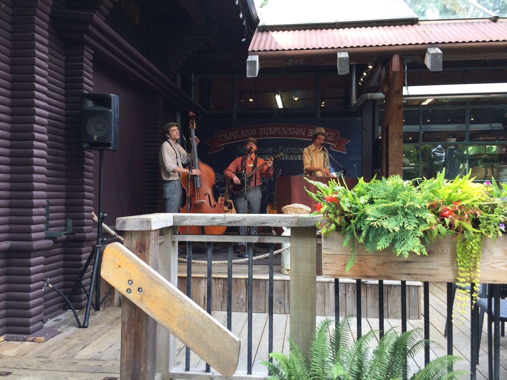 Band performs bluegrass music on a wooden outdoor stage.