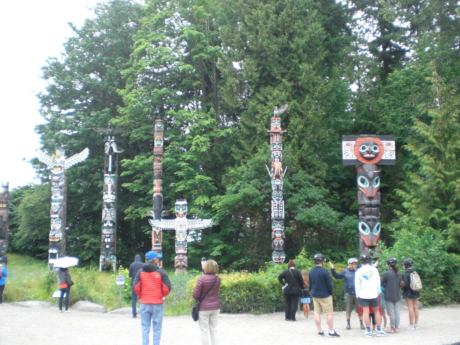 Totem poles in Stanley Park, Vancouver, BC, with tourists.