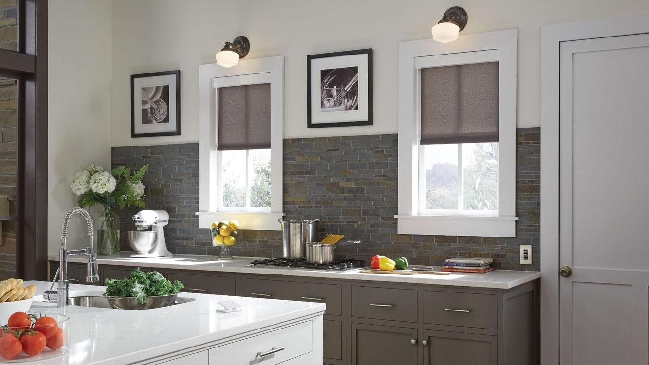 A kitchen with a sink , stove , and three windows.