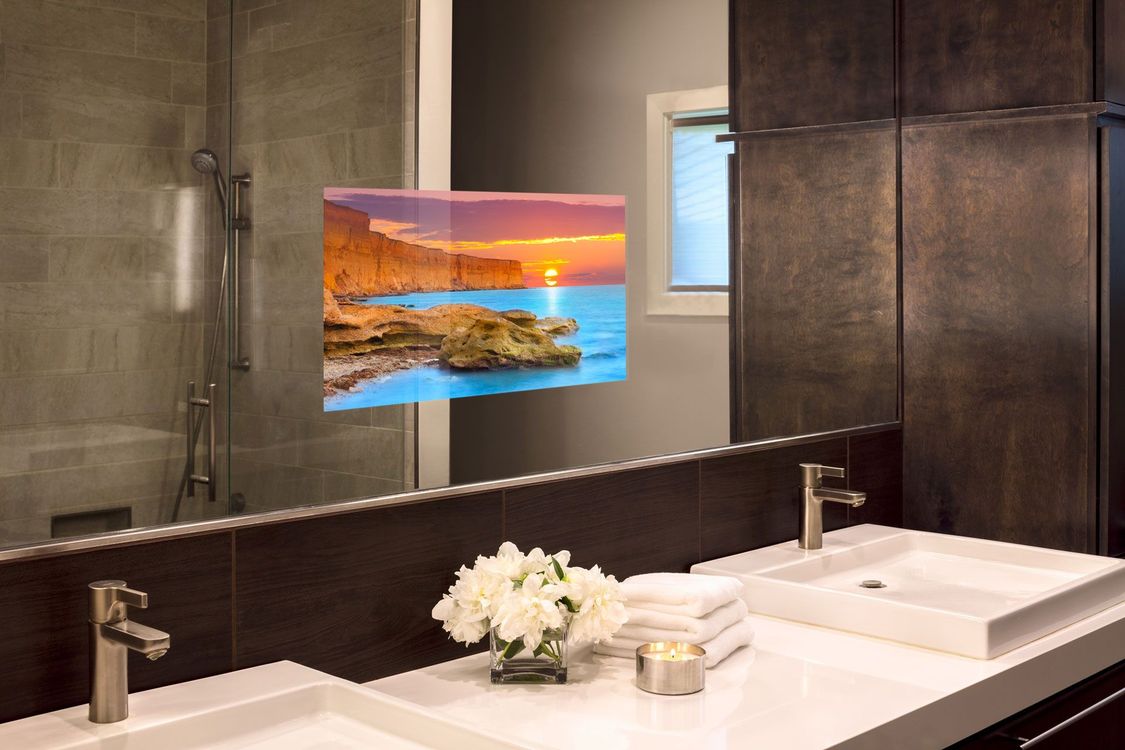 A bathroom with two sinks and a picture on the mirror