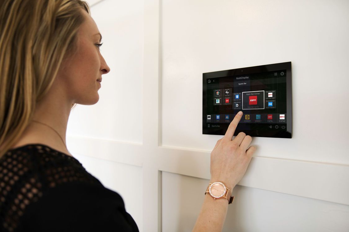 A woman is using a smart device on a wall.