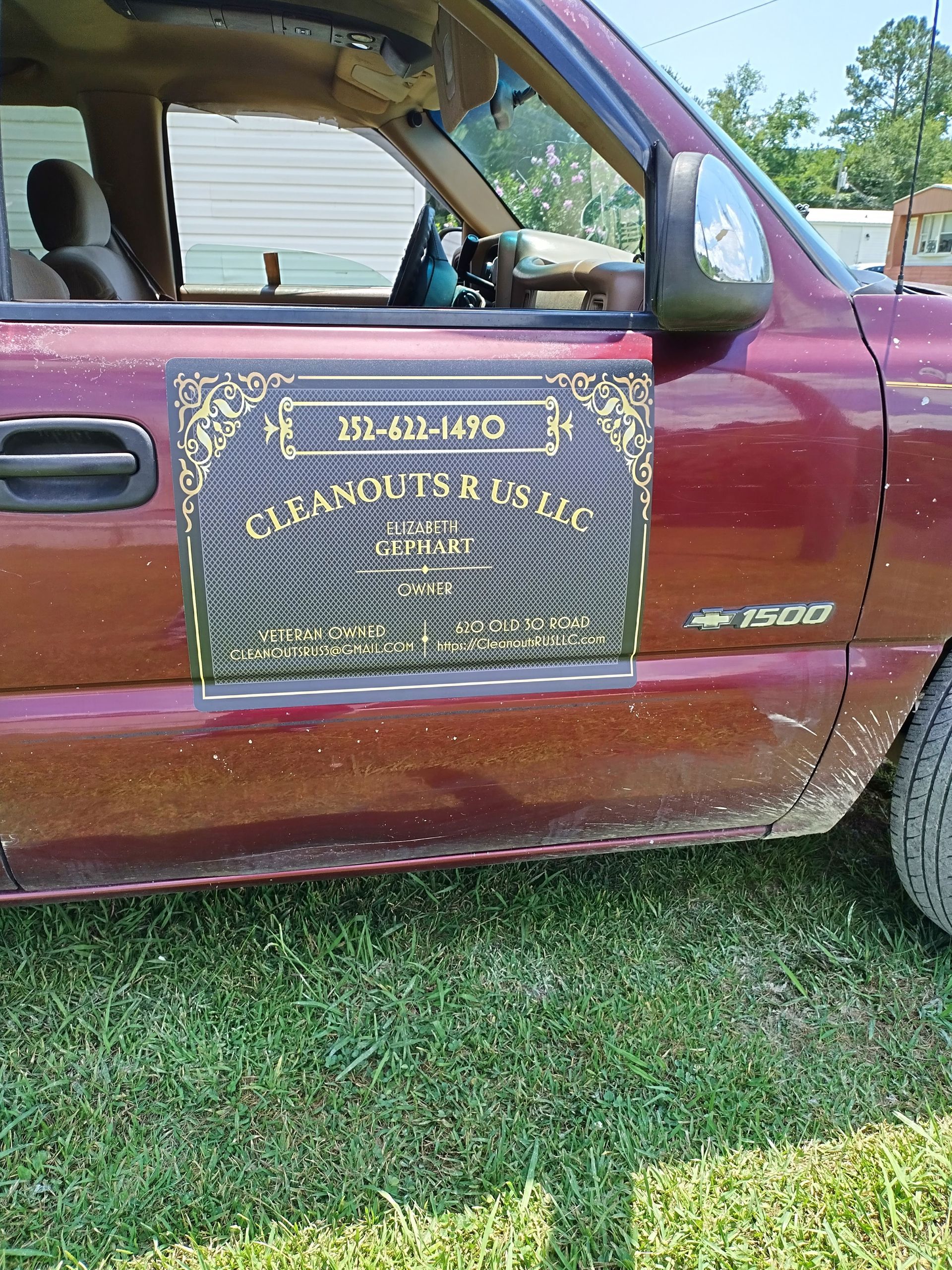 A red truck with a sign on the side that says cleanouts & us llc