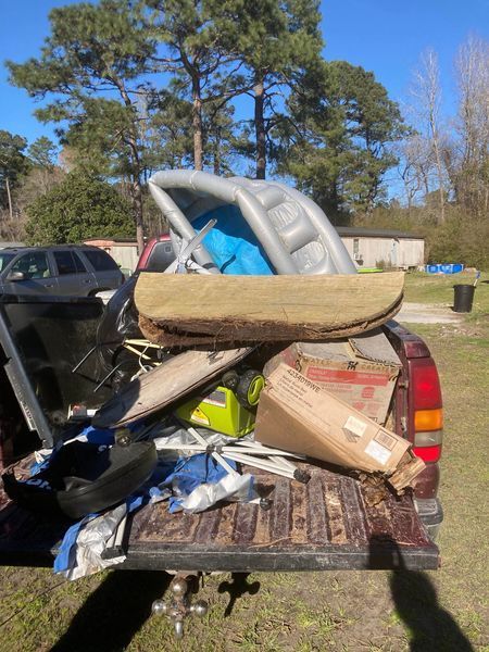 The back of a truck is filled with a lot of junk.