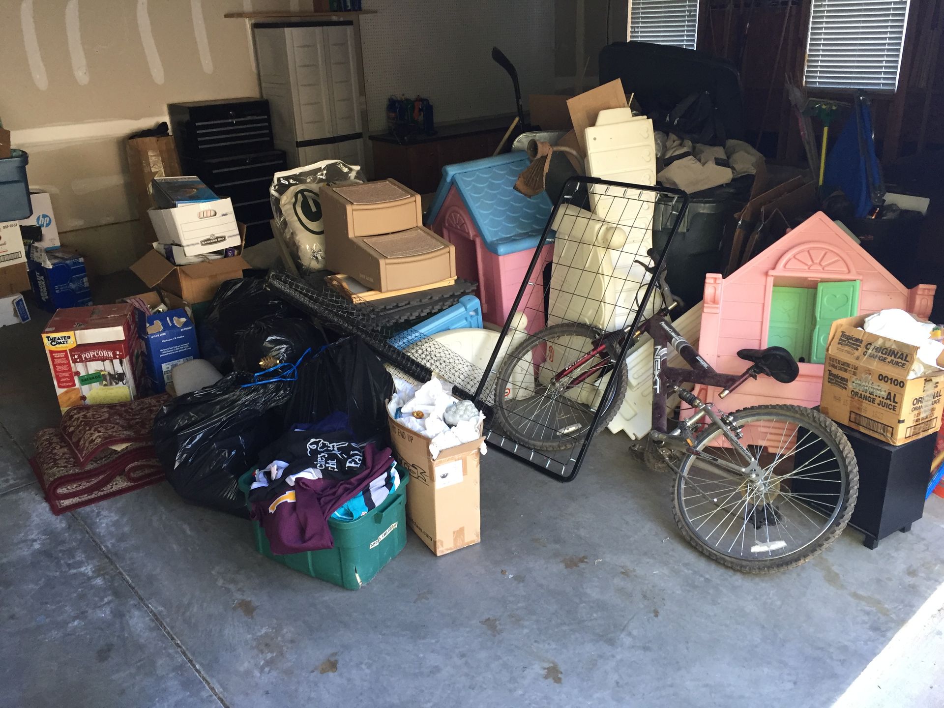 A garage filled with lots of boxes and a bicycle.