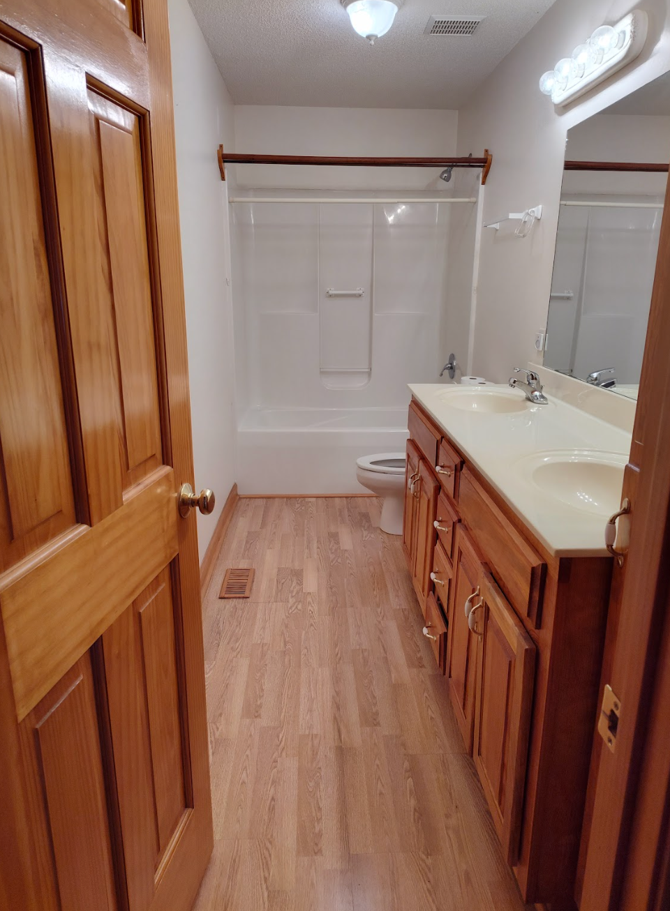 A bathroom with two sinks , a toilet , and a bathtub.