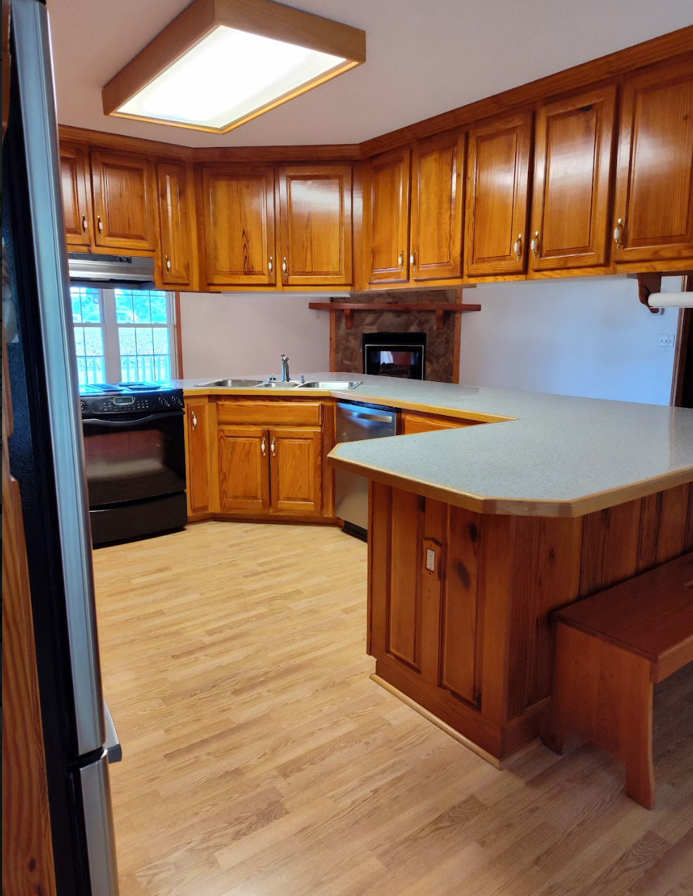 A kitchen with wooden cabinets and stainless steel appliances