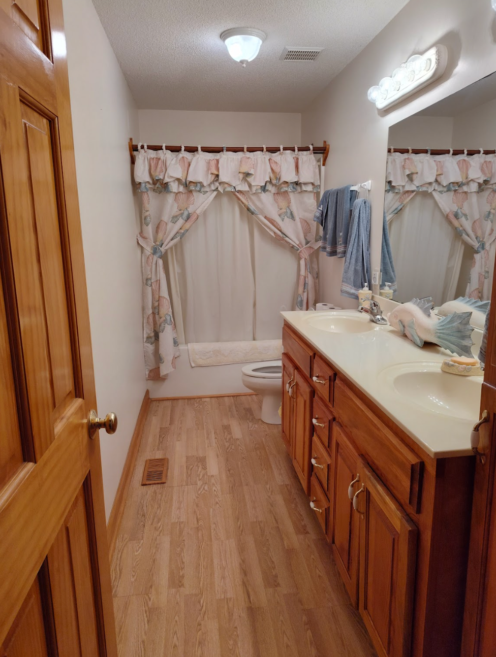 A bathroom with two sinks a toilet and a mirror