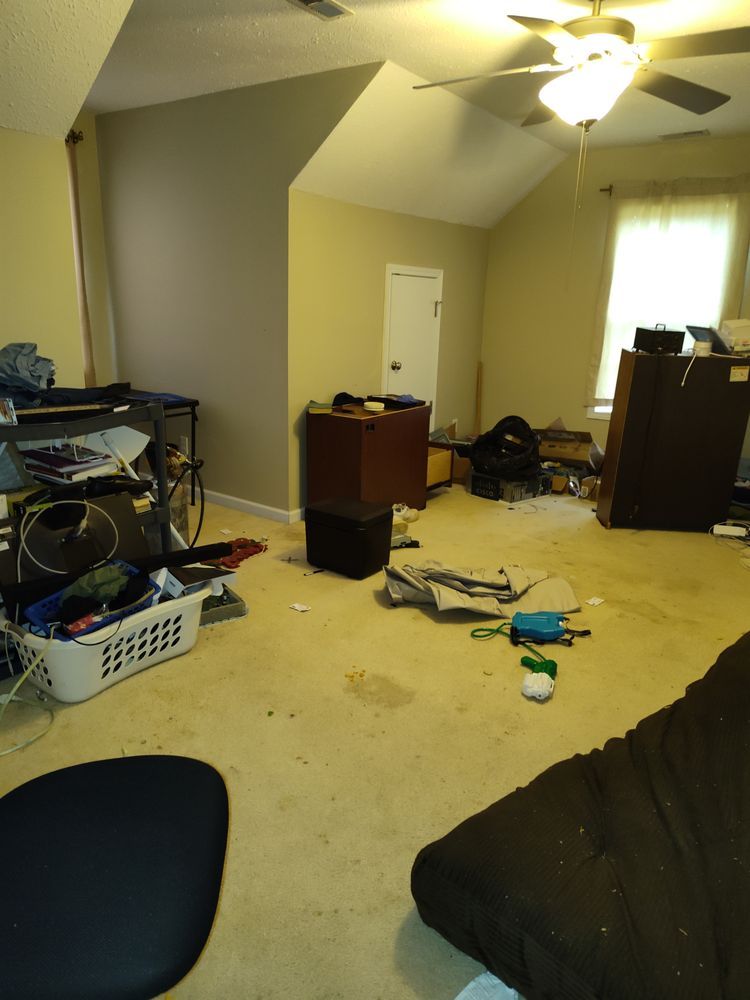 A messy room with a ceiling fan and a basket of laundry