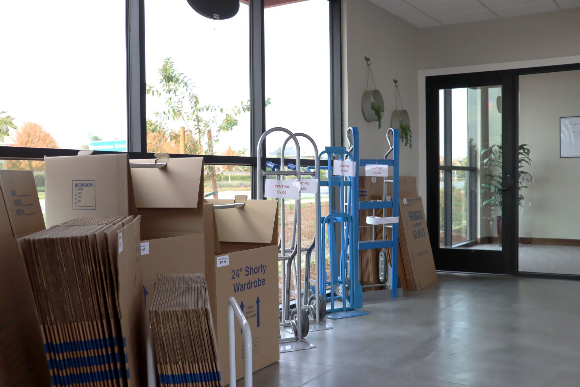 A room filled with boxes and carts in front of a window.