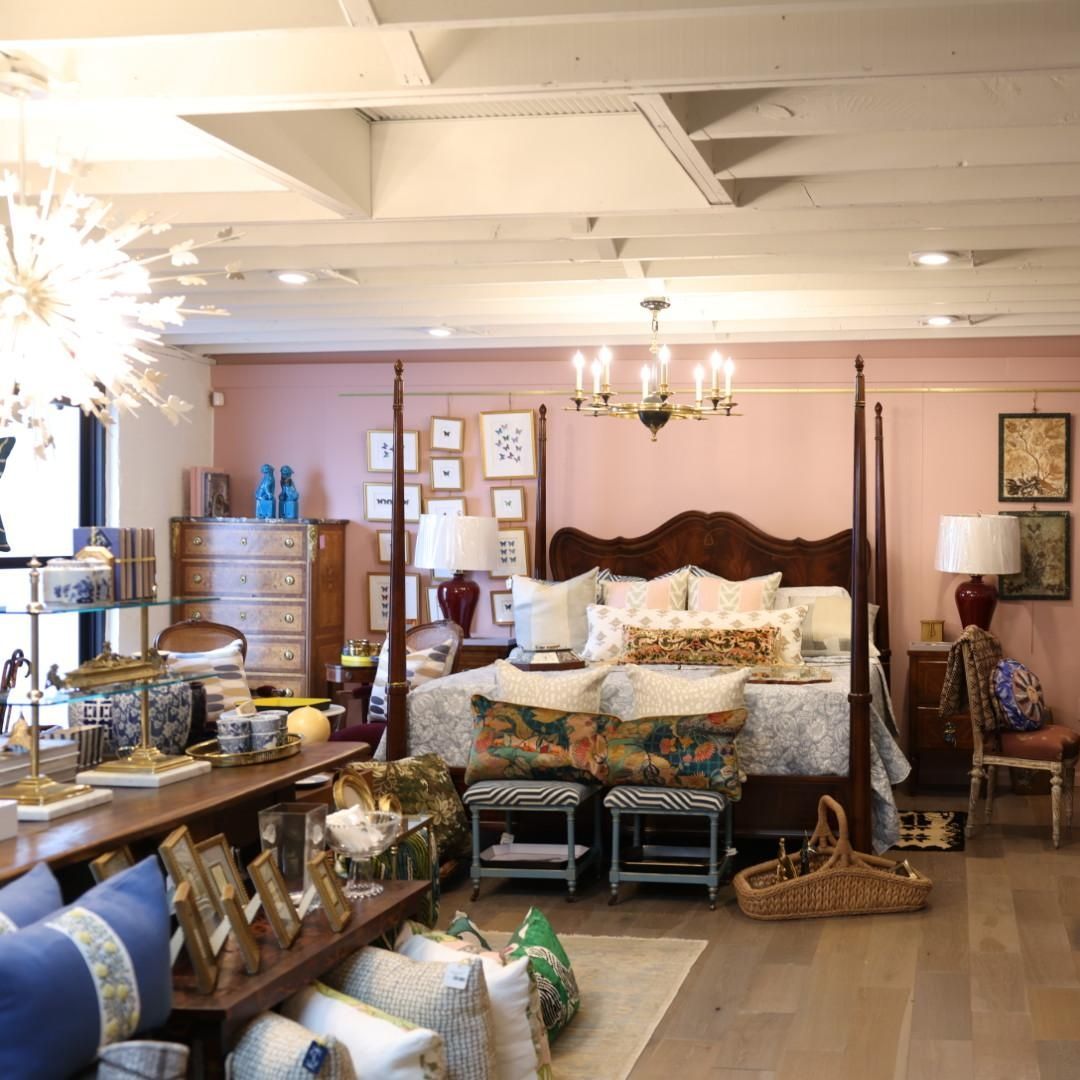 A bedroom with a four poster bed and lots of pillows