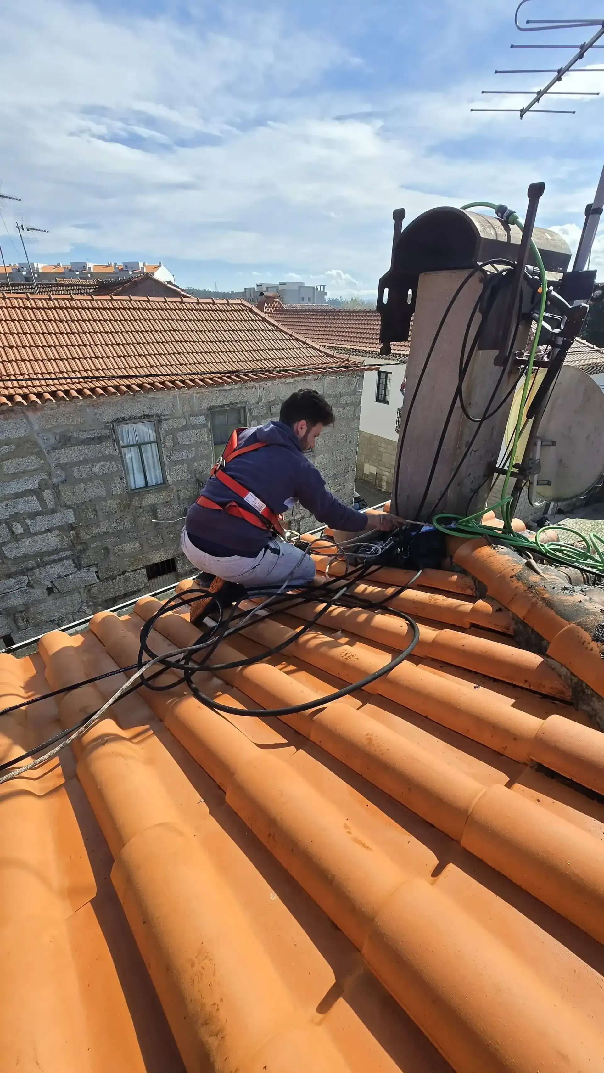 Trabalhador a prender o arnês a um ponto de fixação