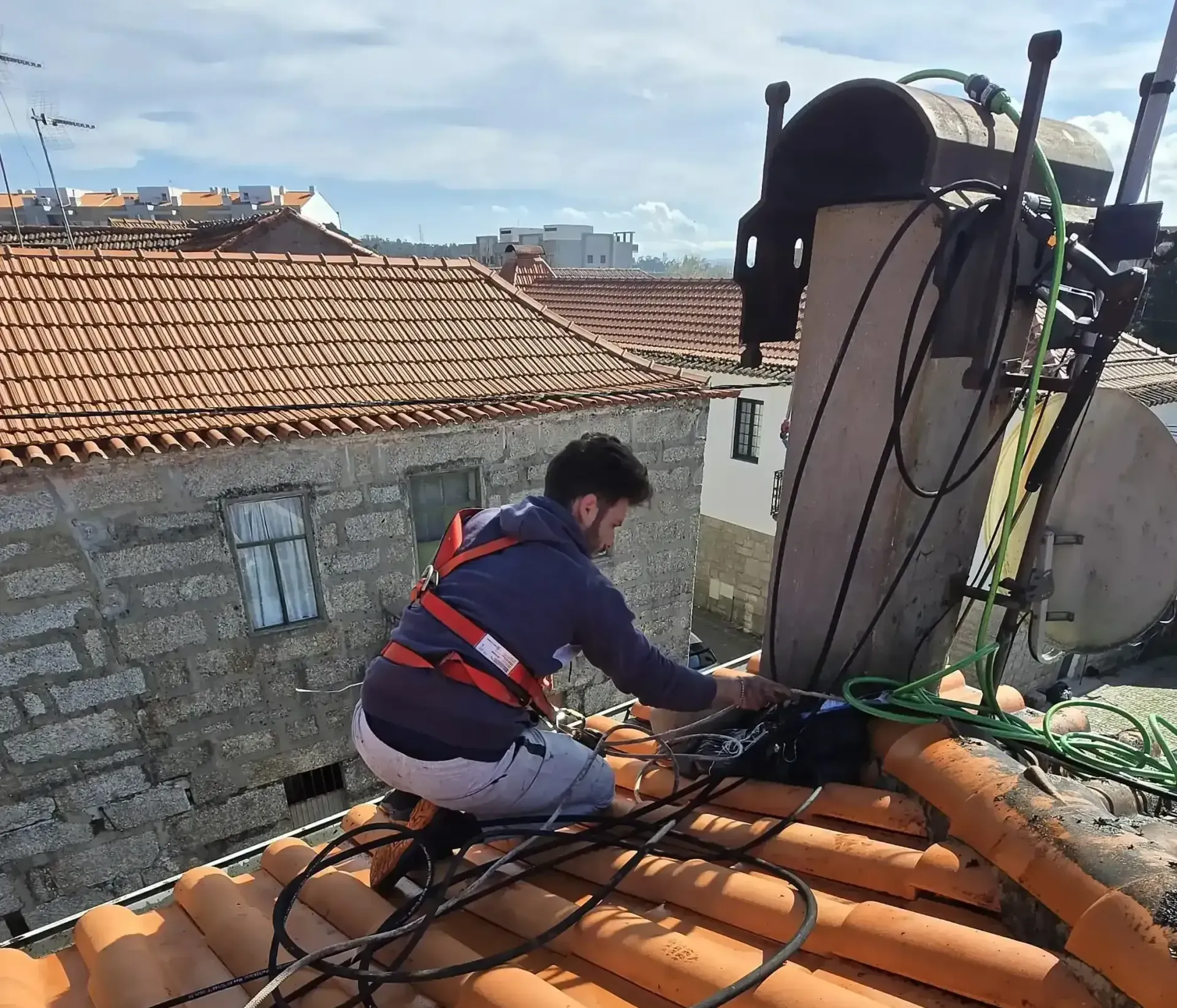 Limpeza de telhados em Porto com sistema de baixa pressão e segurança por arnês.
