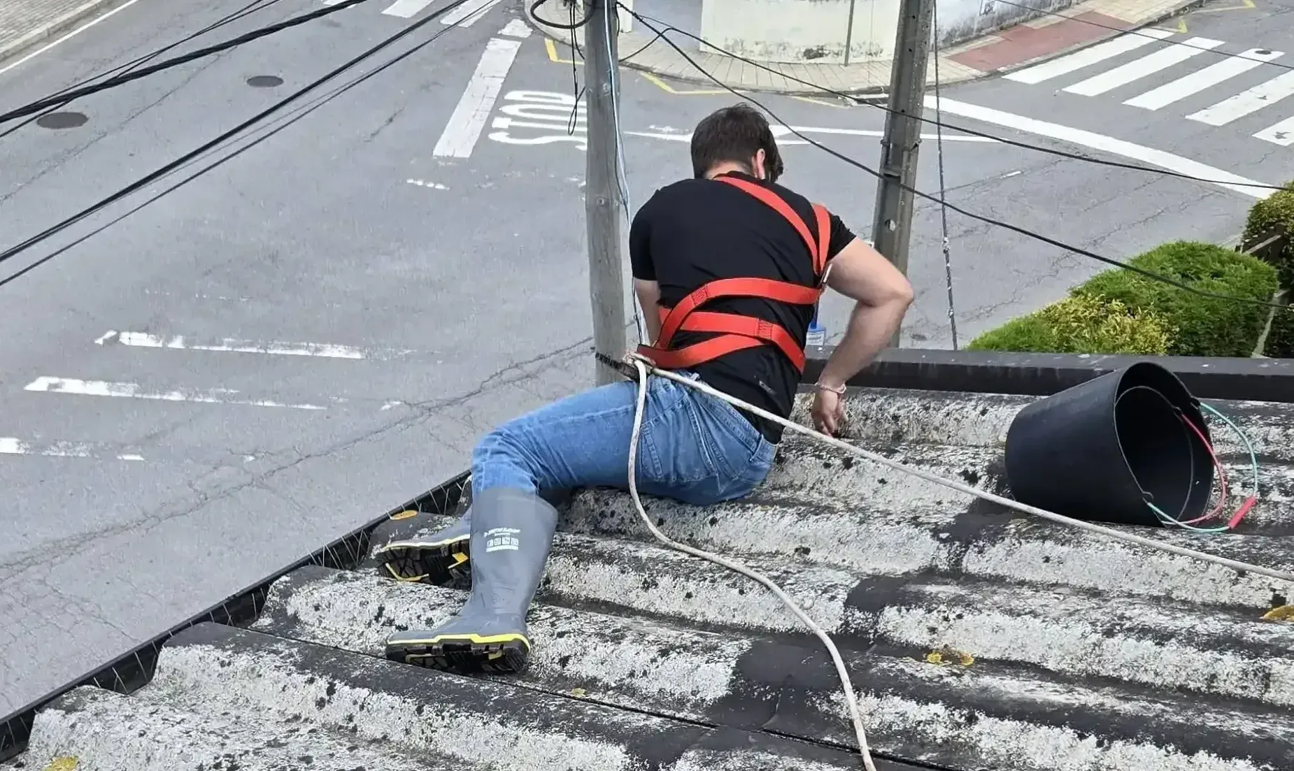Profissional da Nortalis com sistema de arnês em trabalho de limpeza de telhado no Porto