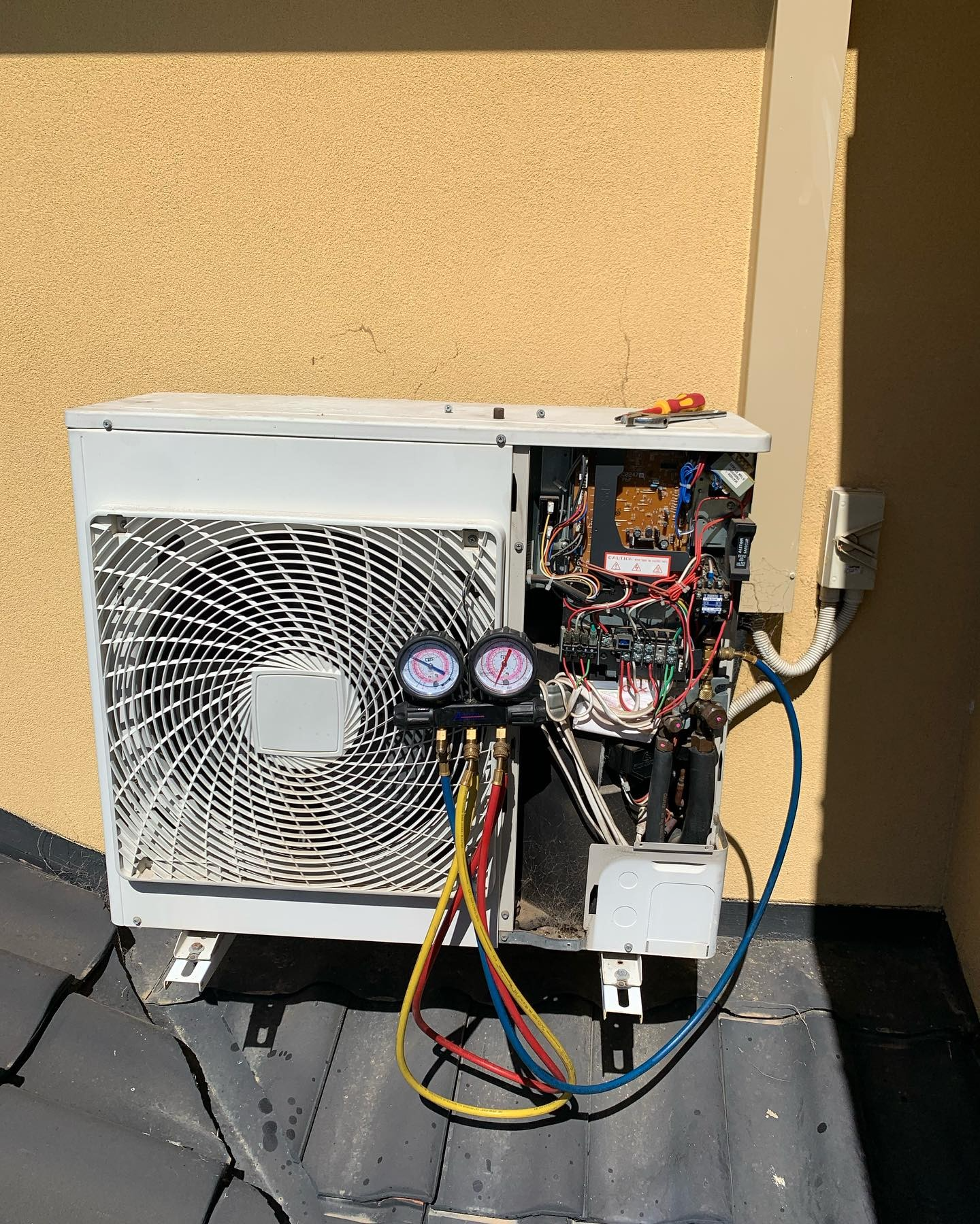 A white air conditioner is sitting on top of a roof.