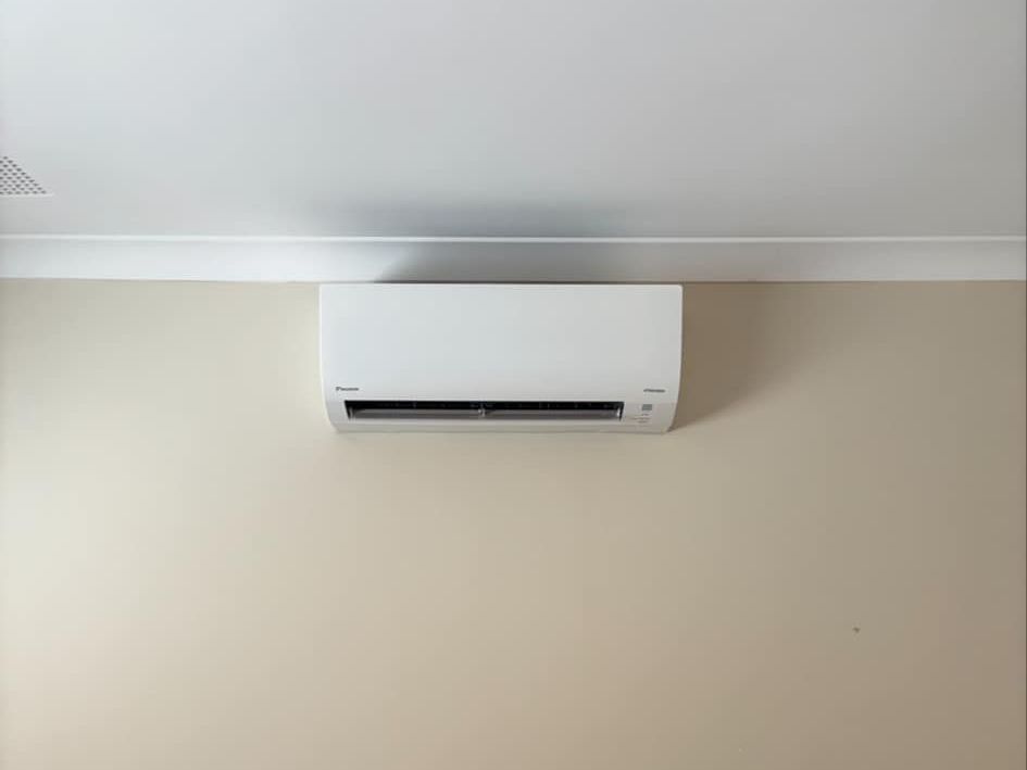 A room with a ladder and a wall mounted air conditioner.
