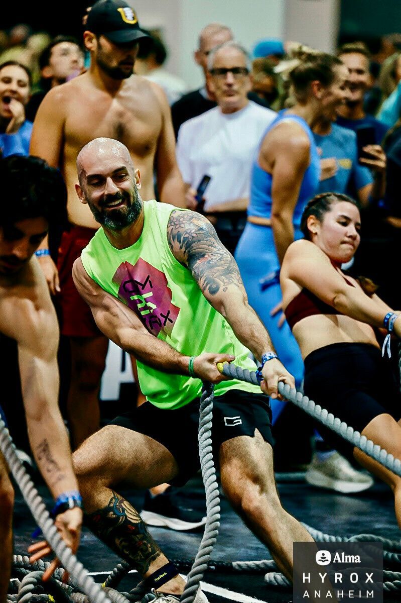 Woman in athletic wear running on a street with cars and trees in the background.