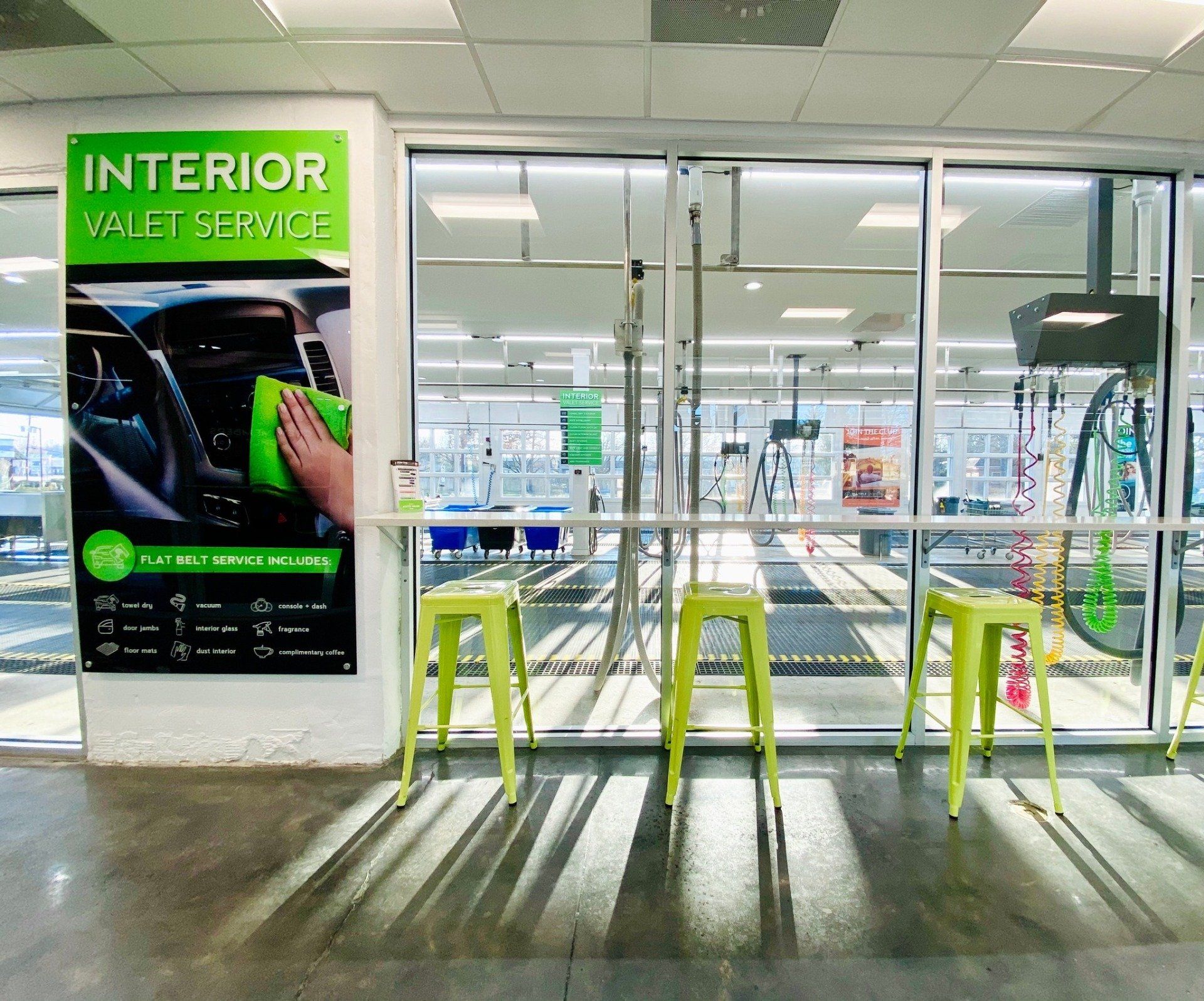 insde of a car wash waiting area with green stools