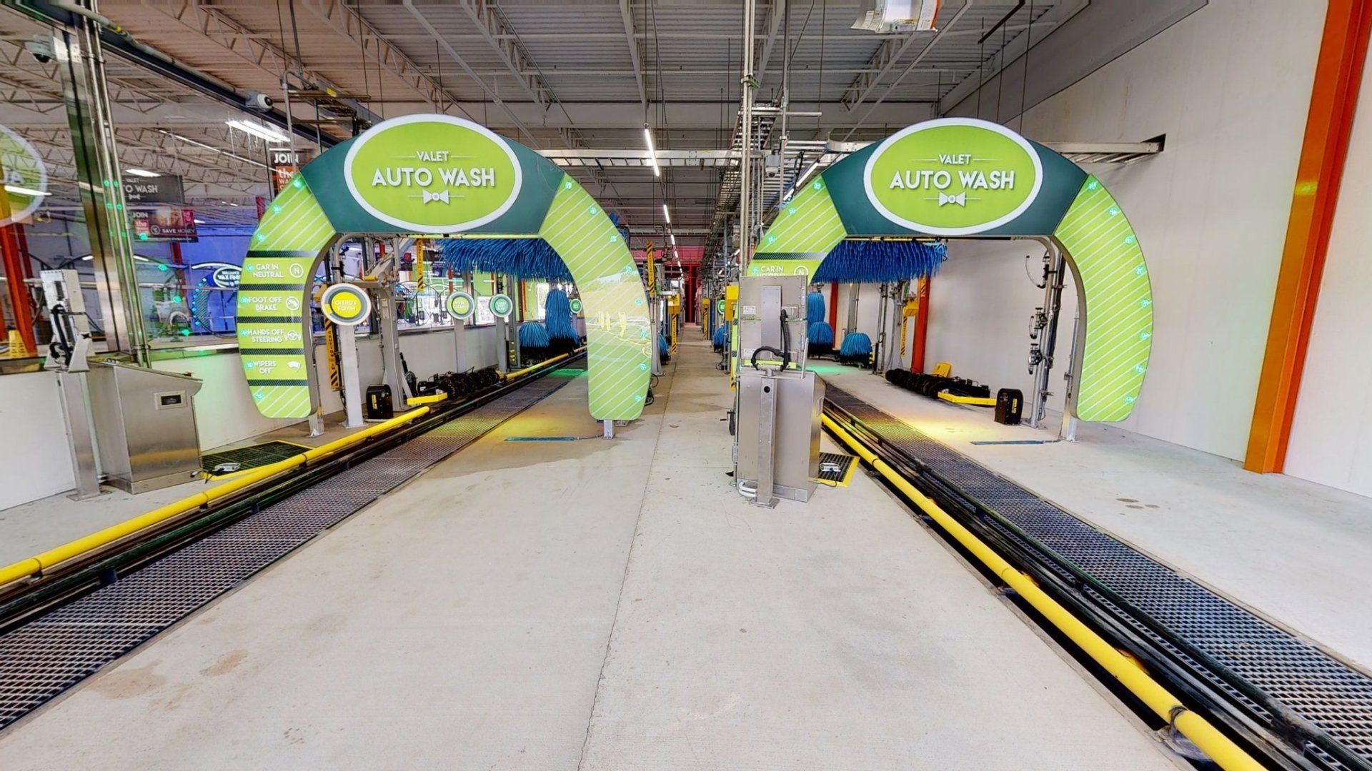 inside of a car wash with two lines and colorful green arch signs