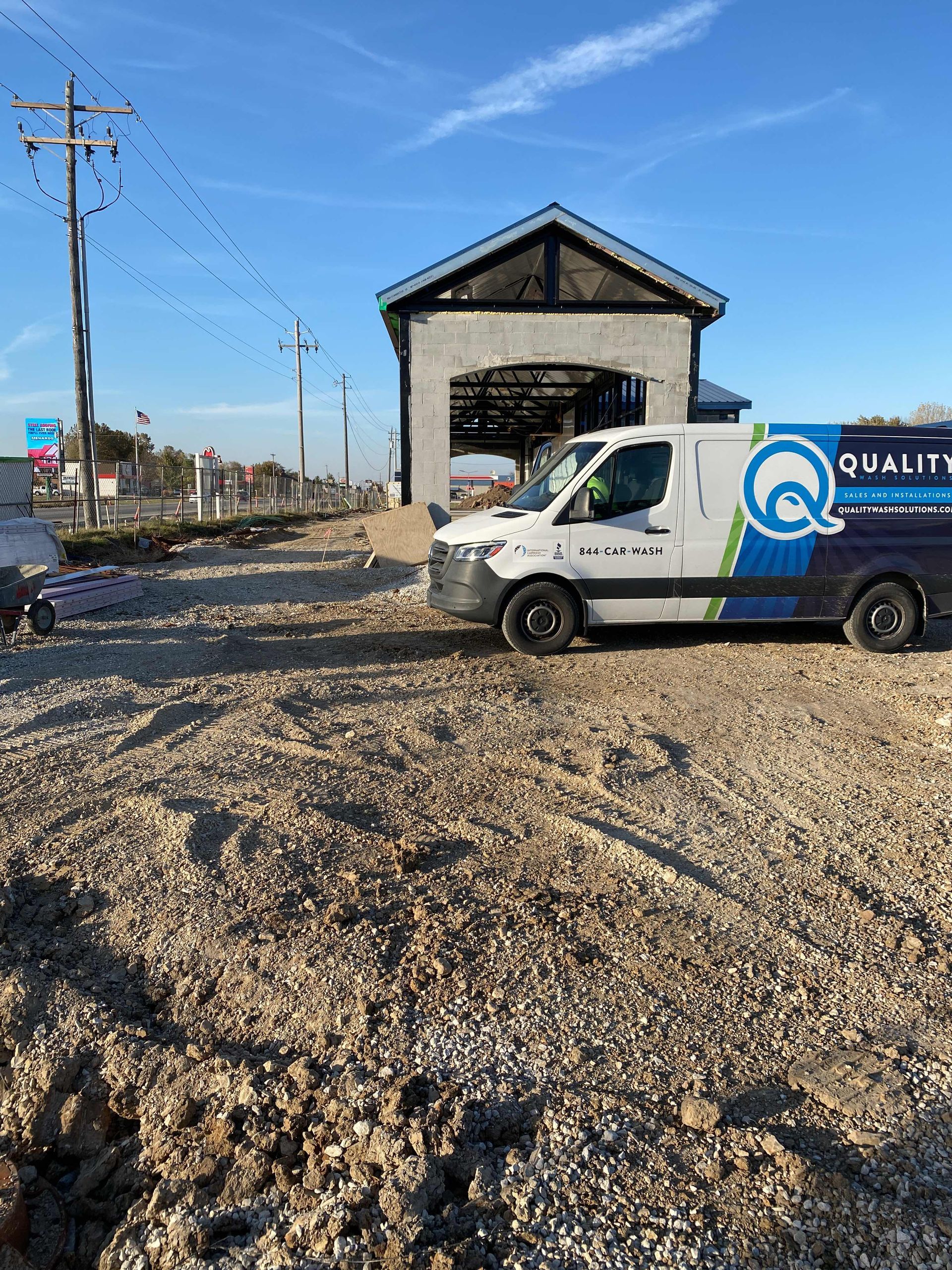 quality wash solutions van in front of a car wash under construction