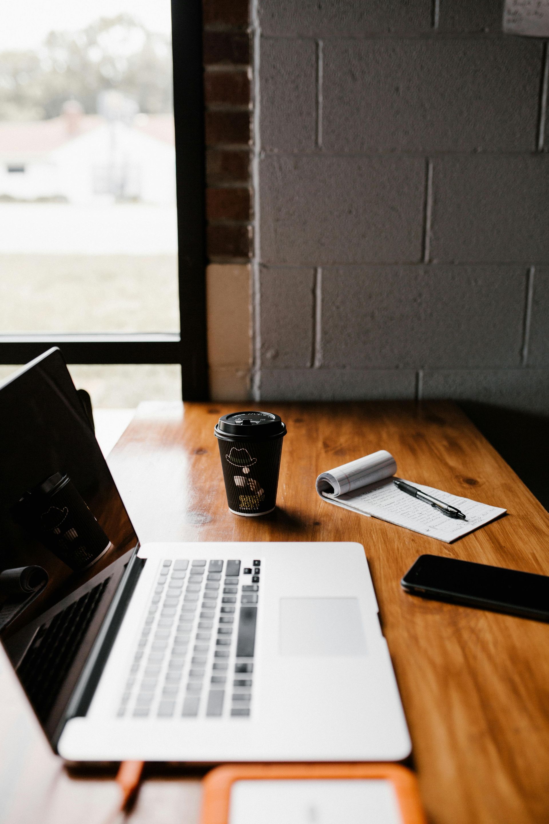 A laptop computer is sitting on a wooden table next to a cup of coffee.