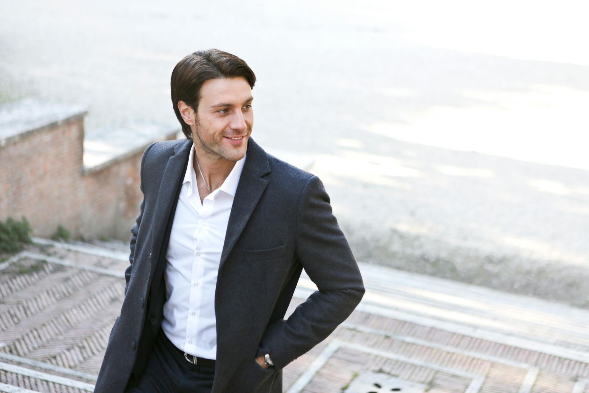 A man in a suit and white shirt is walking down stairs.