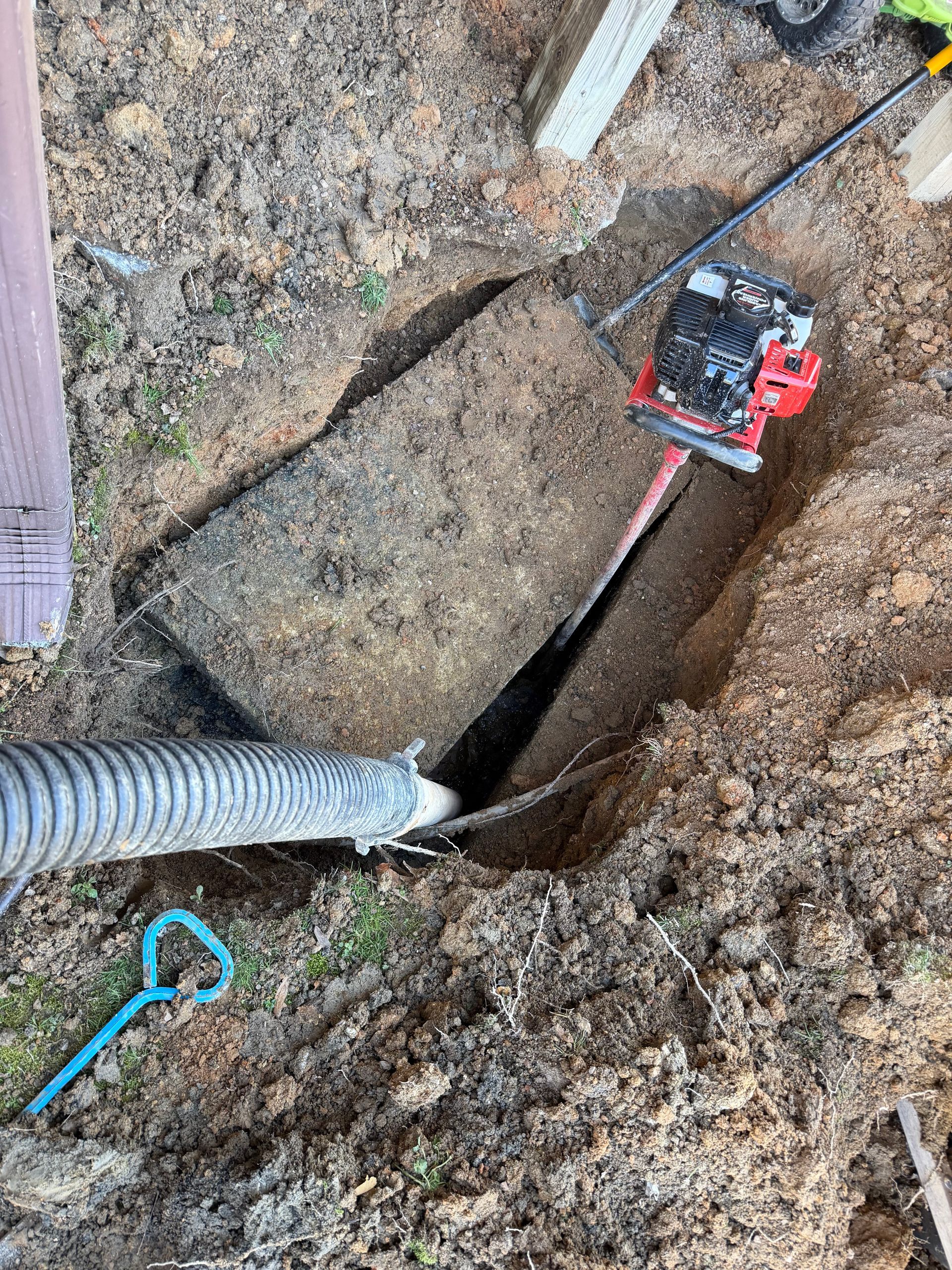 A red and white septic truck is parked in a grassy field.