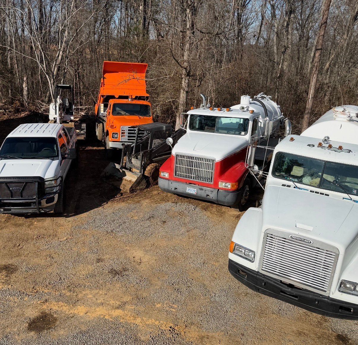 A man is standing in front of a septic pump truck holding a sign that says rapper full.