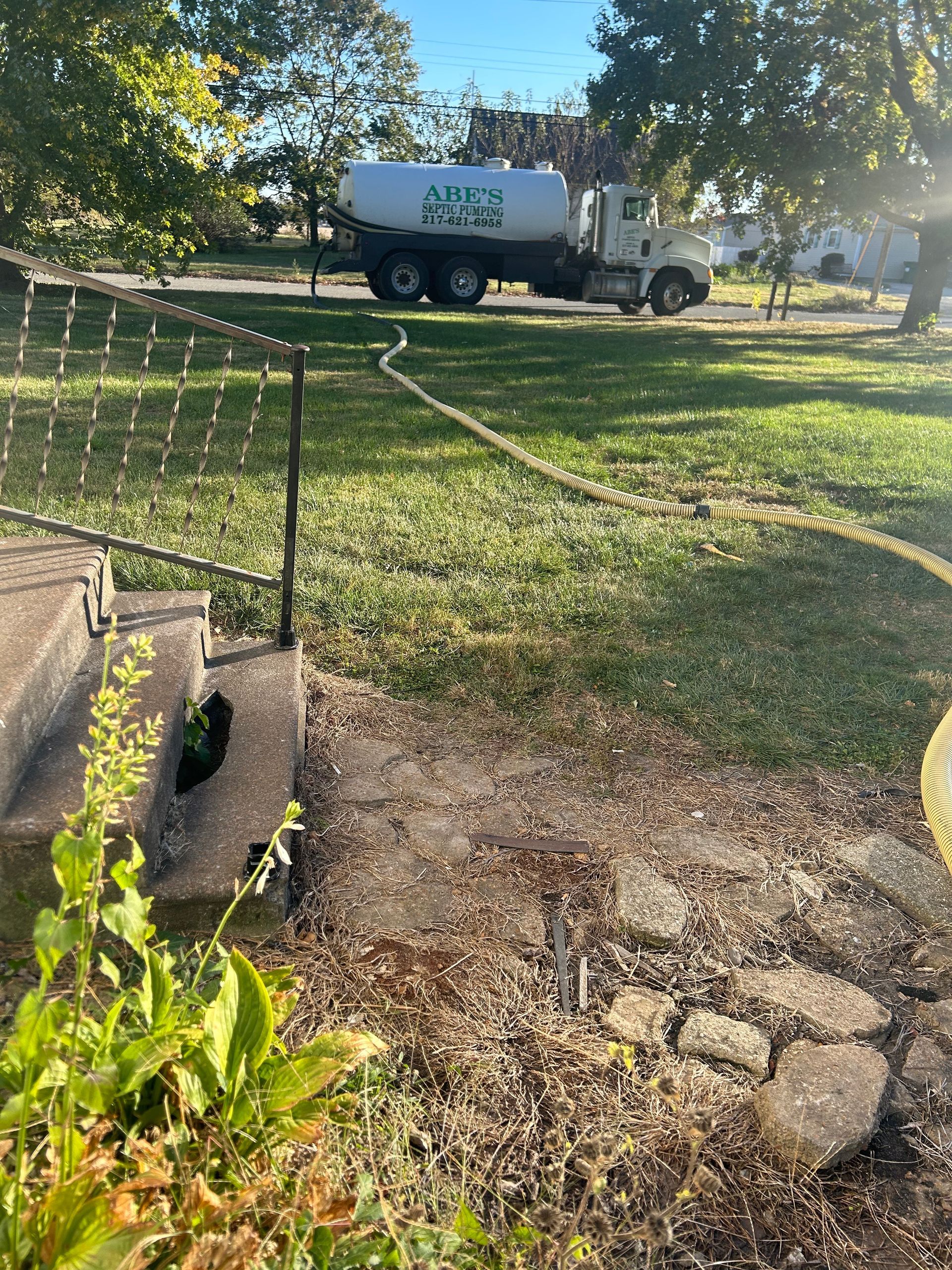 A man is standing in front of a septic pump truck holding a sign that says rapper full.