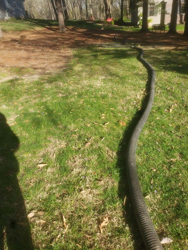 A hose is laying on the grass in a park.