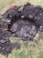 A person is digging a hole in the ground with a shovel.