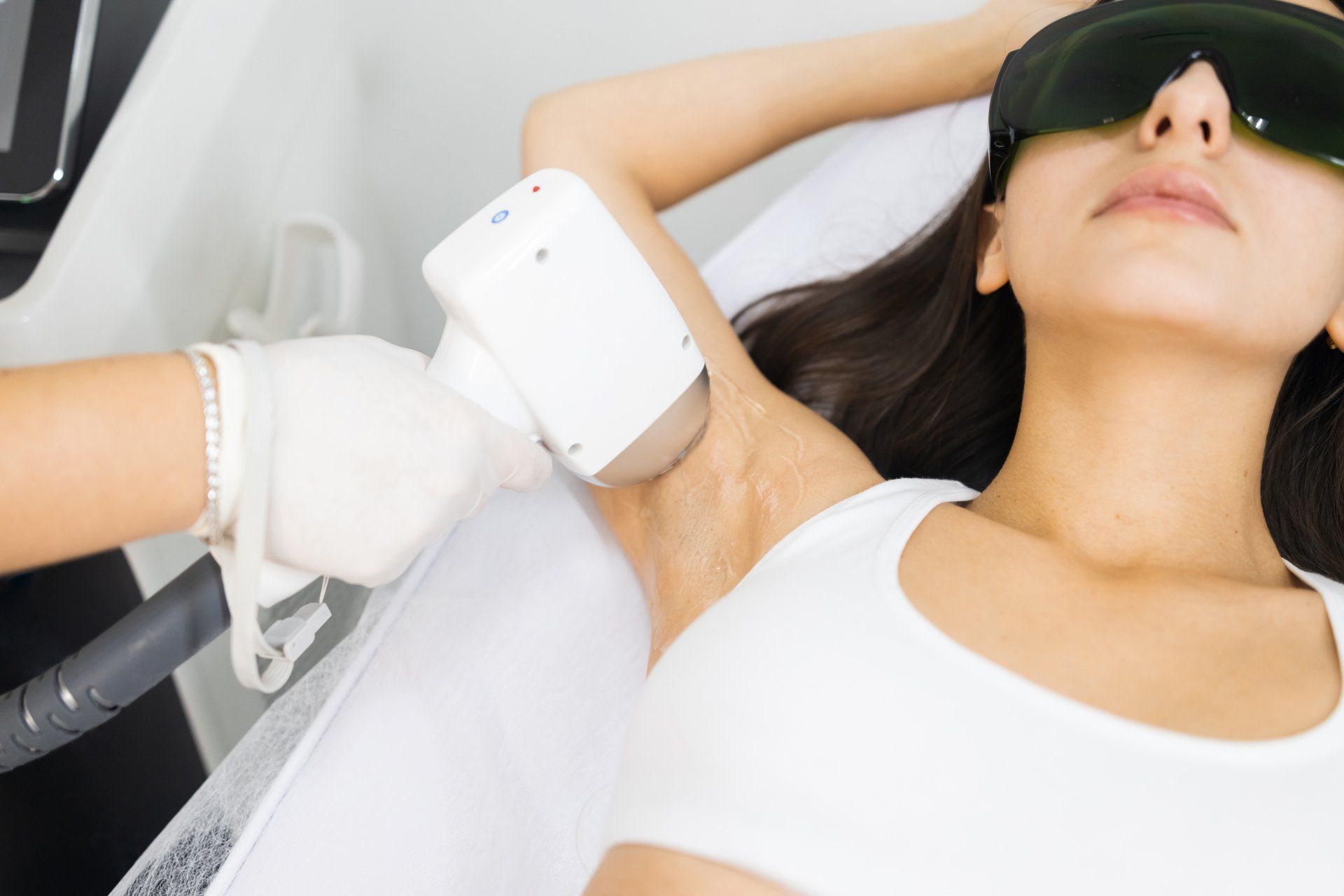 Woman receives laser hair removal treatment on underarm