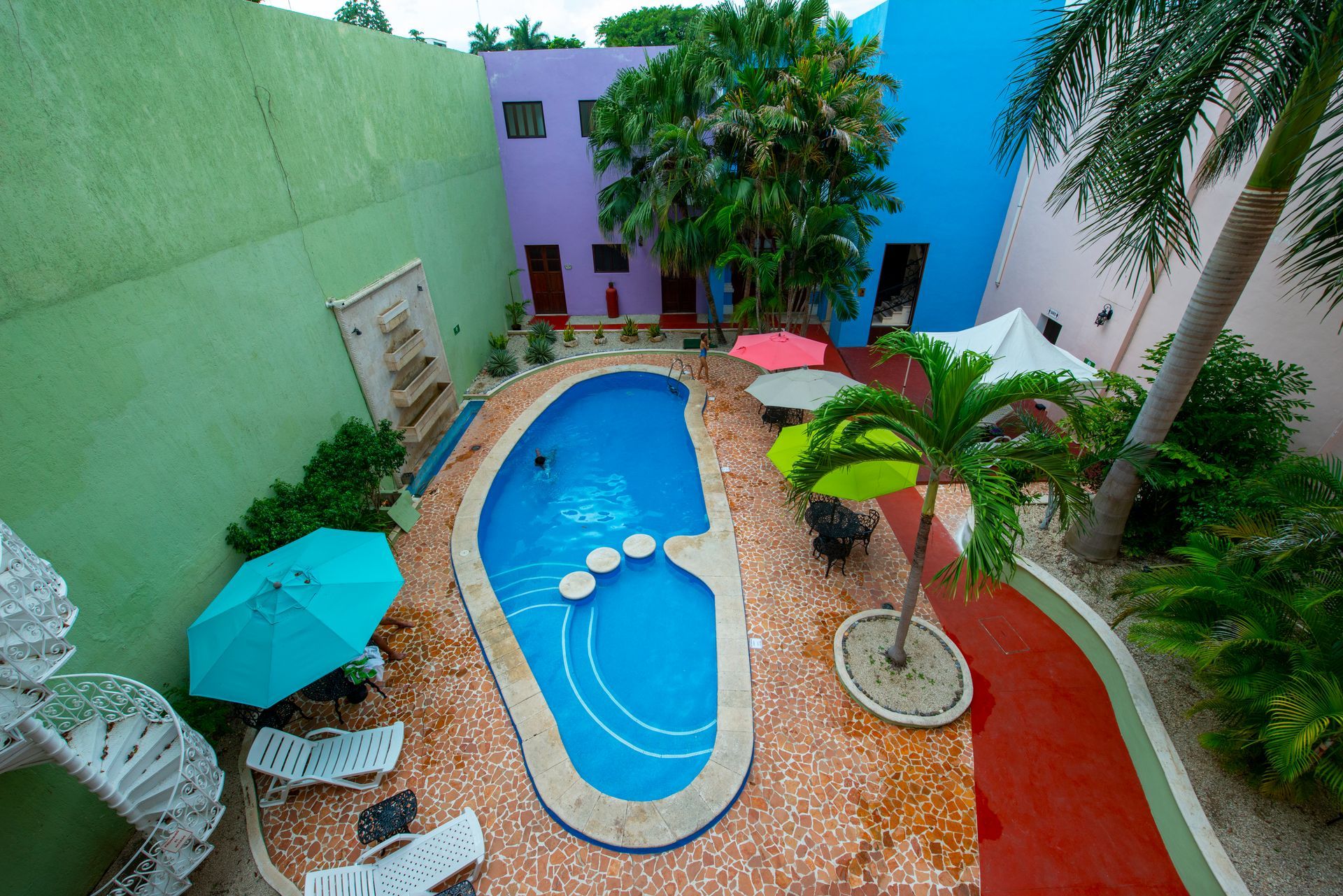 An aerial view of a swimming pool surrounded by chairs and umbrellas