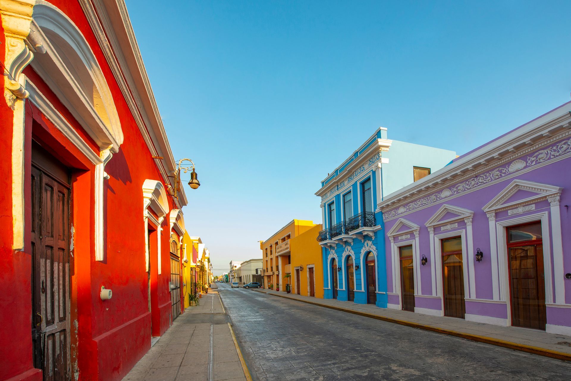 A row of colorful buildings are lined up on a street.