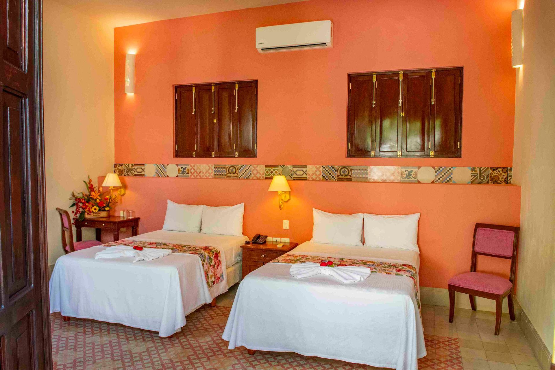 A hotel room with two beds and a chair.