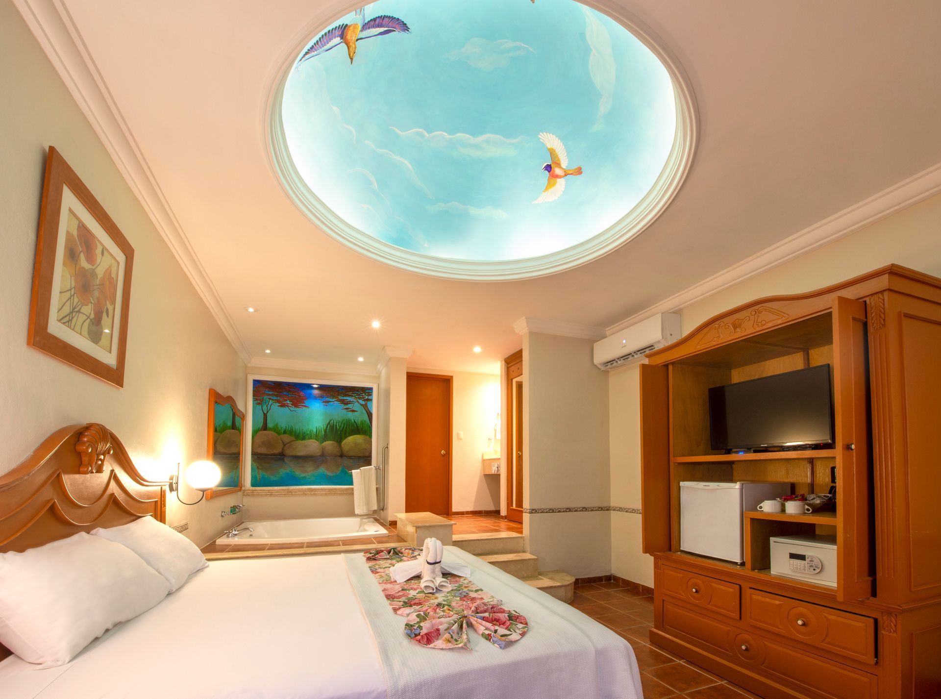 A hotel room with a king size bed and a television