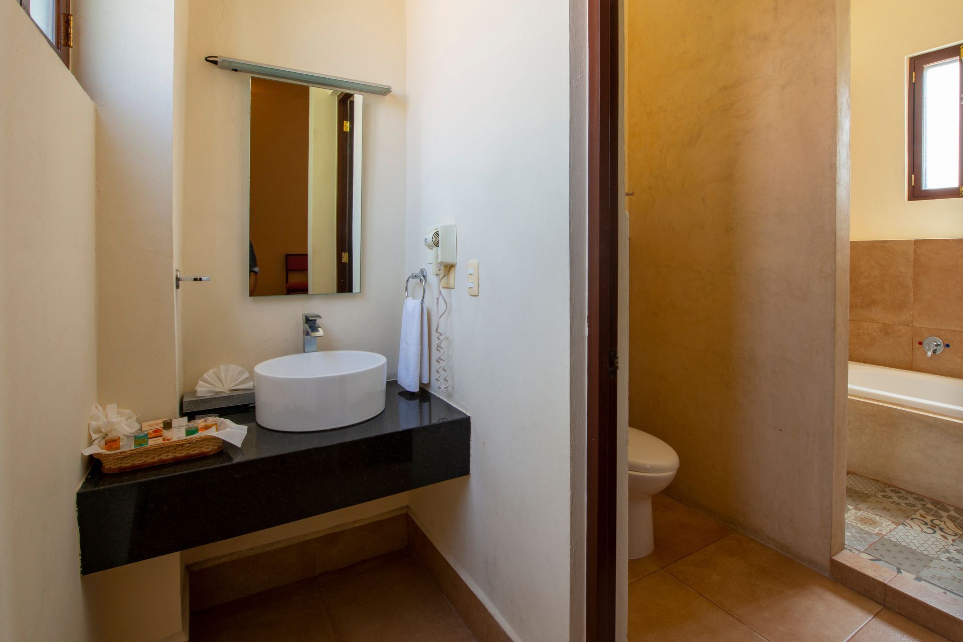A bathroom with a sink , toilet , mirror and bathtub.