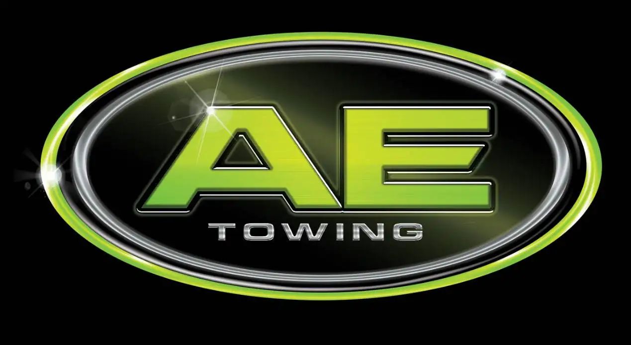 AE Towing logo with lime green “AE” on a black oval badge