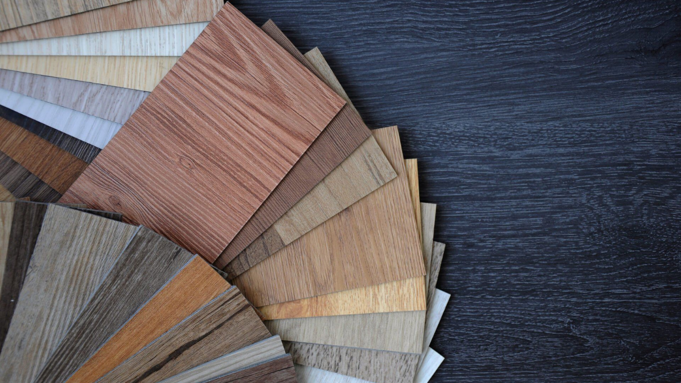 Gray carpeted floor transitioning to light gray wooden floor with a metal threshold.