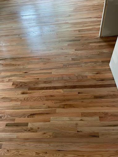 Hardwood floor planks in warm tones.