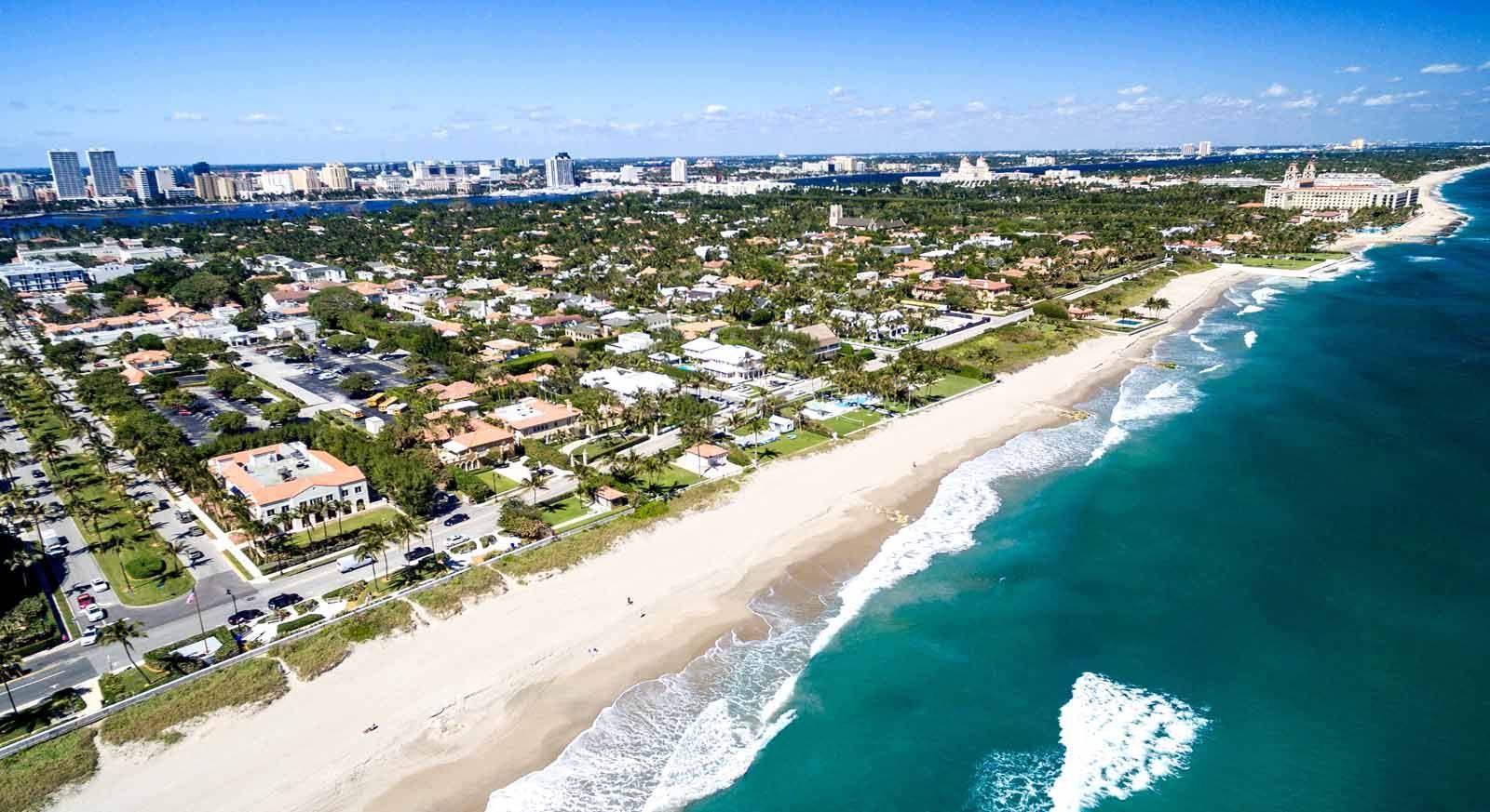 An aerial view of a beach with a city in the background.