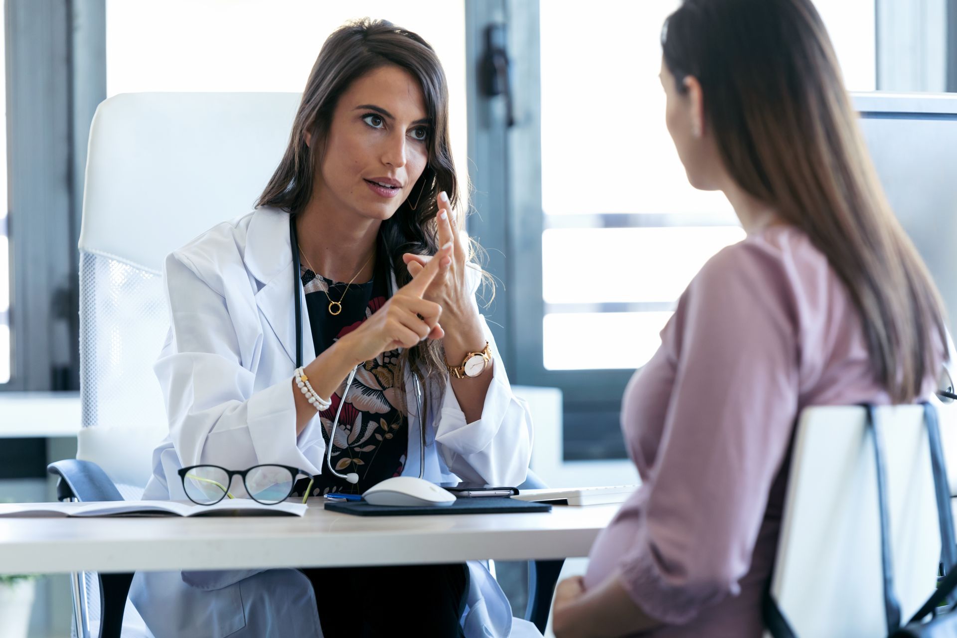 A doctor is talking to her pregnant patient. A doctor is talking to her pregnant patient.