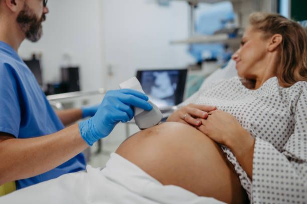 Obstetrician performing a prenatal ultrasound on a pregnant woman.