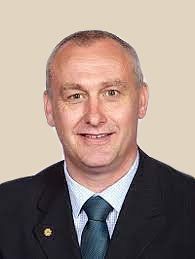 A man in a suit and tie is smiling for the camera.