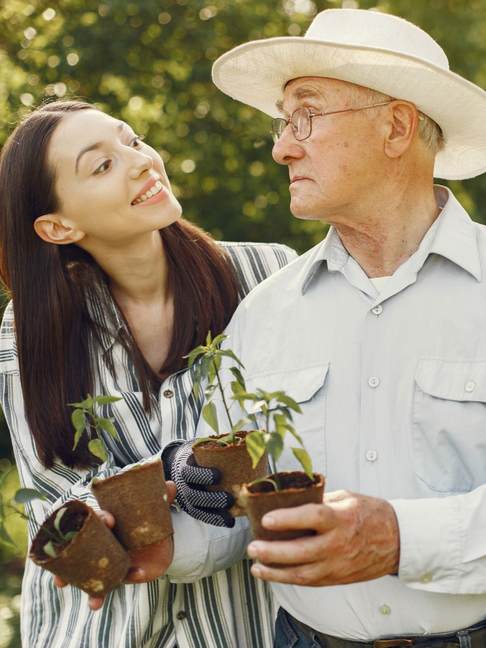 A man and a woman are sitting on the floor in a gym . the woman is bandaging the man 's ankle.